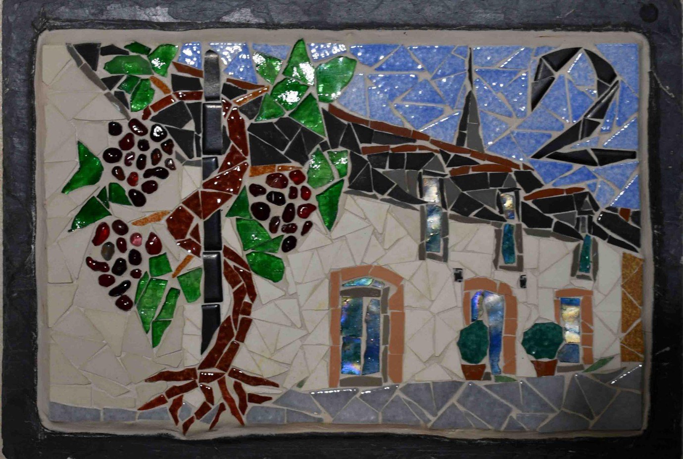 Numéro 2 avec de la vigne grimpante et un clocher derrière une longère
